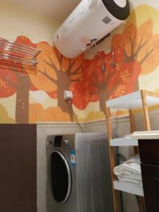a washing machine next to a wall with trees on it at FRAGRANCE House Hanxi Changlong Panyu Wanda Plaza Store in Guangzhou