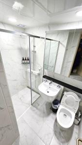 a white bathroom with a toilet and a sink at Urban Square in Seoul