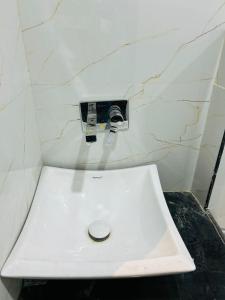 a white sink in a bathroom with a marble wall at Swastik Inn in Varanasi