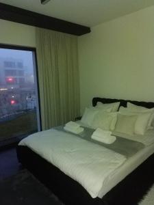 ein großes Bett in einem Zimmer mit Fenster in der Unterkunft Baltic Riviera Apartments -Solmarina in Wiślinka