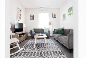una sala de estar con un sofá y una mesa en Charming Inner City Stay with parking & wifi, en Launceston
