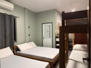 a room with two beds and a bunk bed at Uno Dus Tourist Inn in Itaytay