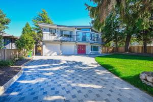 a house with a red door and a driveway at Cozy Home with 3BR 4Bath near Richmond Steveston Village in Richmond