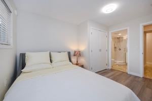 Un dormitorio con una gran cama blanca y un baño. en Cozy Home with 3BR 4Bath near Richmond Steveston Village, en Richmond 17 fotos más