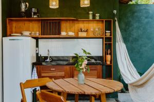 a kitchen with a wooden table and a refrigerator at Recanto Alter do Chão in Alter do Chao
