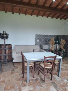 a table and chairs in a living room with a couch at Chicco di grano in Foiano della Chiana