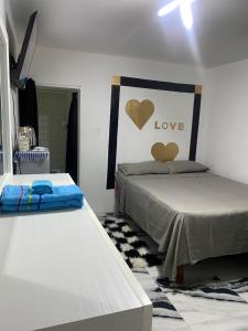 a bedroom with two beds and a sign that says love at White Room Sparks in Spanish Town