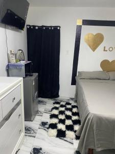 a bedroom with a bed and a black and white rug at White Room Sparks in Spanish Town