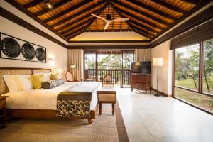 a bedroom with a large bed and a television in it at Anantara Peace Haven Tangalle Resort in Tangalle