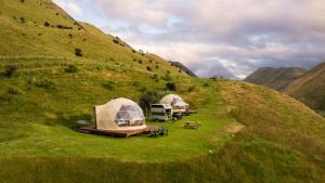 un gruppo di tende su una collina erbosa di Glam Camping Queenstown a Queenstown Altre 38 foto