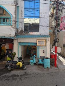 ein Motorrad, das in einer Garage neben einem Gebäude geparkt ist in der Unterkunft Serendipity Hostel & Cats Cafe in Rishikesh