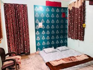 a room with a bed and a wall with curtains at Family Home Stay in Prayagraj