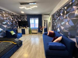 un salon avec un canapé bleu et un mur géométrique dans l'établissement Kitty Downtown Apartman, à Debrecen 47 autres photos