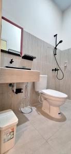 a bathroom with a toilet and a sink and a mirror at Tangkoko Hideaway Cottage in Pulau Mogogimbun +48 photos