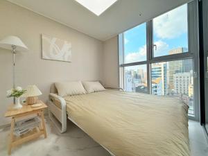 een slaapkamer met een groot bed en een groot raam bij The Comfort in Seoul