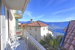 un balcone con sedie e vista sulle montagne di Lugano Bay View a Cademario