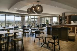 a restaurant with tables and chairs and windows at Hotel Vista Sierra in Auburn