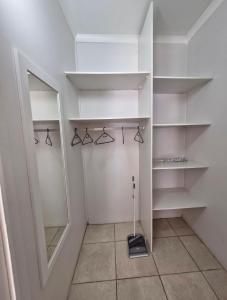 a walk in closet with shelves and a mirror at Ivy Place Studio Apartment in Cape Town