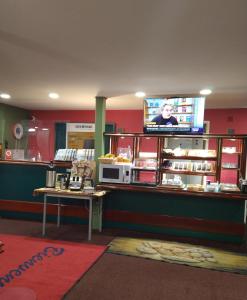 a restaurant with a counter with a tv on the wall at Quick Palace Le Mans in Saint-Saturnin