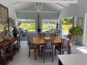 a dining room with a table and chairs at The Pijper House - Brackenridge Eco Estate Plettenberg Bay in Plettenberg Bay