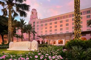 ein großes rosa Gebäude mit einem Uhrturm und Blumen in der Unterkunft The Vinoy Resort & Golf Club, Autograph Collection in St Petersburg + 136 Fotos