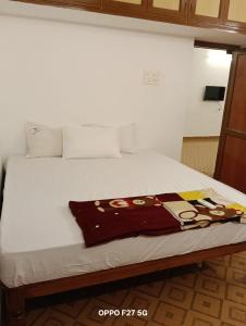 a white bed with a blanket on top of it at Vj Villa Home Stay in Puducherry