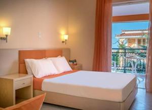 een slaapkamer met een bed en een groot raam bij The Dream Hotel in Tragaki +37 foto's