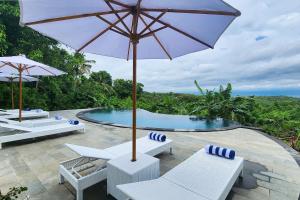a patio with chairs and an umbrella and a pool at Nature Hill Penida in Nusa Penida +39 photos