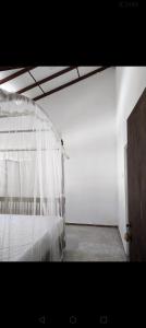 a bedroom with a bed with a white canopy at Galle Heart in Galle