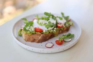 a plate with a piece of bread with a salad on it at Nature Hill Penida in Nusa Penida