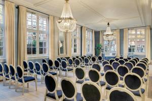 a conference room with chairs and a table and chandeliers at The College Hotel Amsterdam, Autograph Collection in Amsterdam