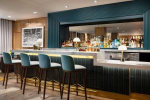 a bar with blue bar stools and a mirror at Residence Inn by Marriott New York Downtown Manhattan/World Trade Center Area in New York