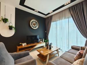 a living room with a couch and a tv at SKS Pavillion Residences Johor Bahru in Johor Bahru