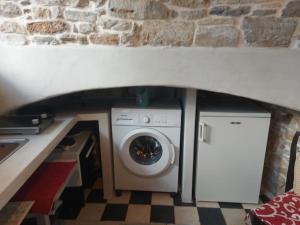 lavatrice e asciugatrice sotto un muro di pietra di Fasolas square studio 15m2 is located 30 stairs up from the main road and it is in the old market fasolas and next to the museums a Philotium