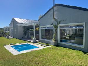 a house with a swimming pool in the yard at The Pijper House - Brackenridge Eco Estate Plettenberg Bay in Plettenberg Bay