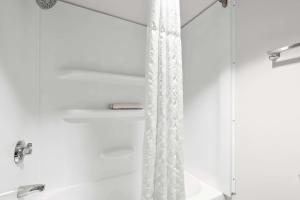 a shower with a white shower curtain in a bathroom at Comfort Inn & Suites near Kino Sports Complex in Tucson +21 photos