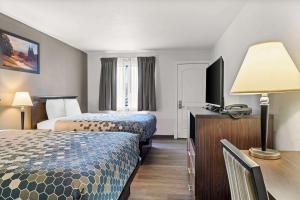 a hotel room with two beds and a flat screen tv at FairBridge Inn Express Billings Airport in Billings