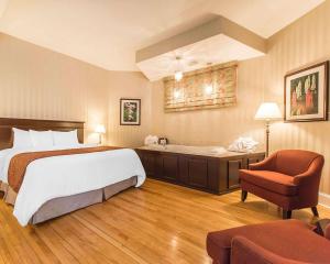 a hotel room with a bed and a bath tub at Quality Inn & Suites Downtown in Charlottetown +42 photos