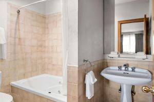 a bathroom with a tub and a sink and a bath tub at FairBridge Inn Express Billings Airport in Billings +19 photos