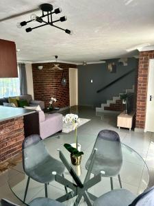 a living room with two chairs and a glass table at Le Com Home in Baragwanath