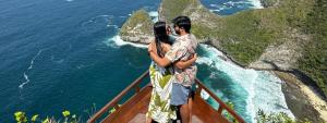 un hombre y una mujer de pie en el borde de un acantilado en One Day West Nusa Penida Tour by Funs Bali Island, en Sanur