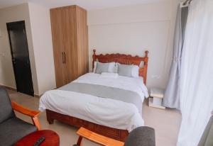 a bedroom with a large bed and a chair at Miiza Realtors in Nairobi