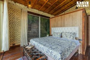 a bedroom with a bed and a large window at StayVista at Pleasance Villa with BBQ & Bonfire in Rānīkhet +17 photos
