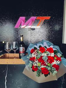 a table with a bunch of flowers and a bottle of wine at Mastery Hotel Nhà Bè in Ho Chi Minh City +55 photos