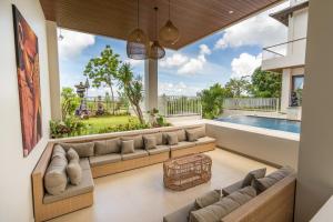 - un salon avec un grand canapé et une piscine dans l'établissement Green GWK Villa, à Jimbaran