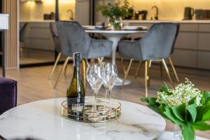 butelka wina na stole z kieliszkami do wina w obiekcie Apartamenty Fenomen - Premium Porto Nadmorskie Tarasy w Kołobrzegu w Kołobrzegu