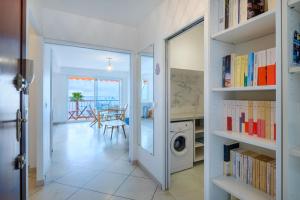 a hallway with a door open to a room with a washing machine at Angelina 2 pièces vue mer - Bej001 in Cros-de-Cagnes