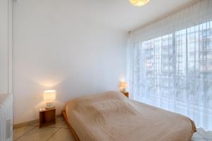 a bedroom with a bed and a large window at Angelina 2 pièces vue mer - Bej001 in Cros-de-Cagnes