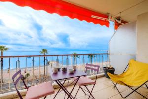 a balcony with a table and chairs and a view of the beach at Angelina 2 pièces vue mer - Bej001 in Cros-de-Cagnes