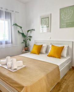 Un dormitorio con una cama grande con almohadas amarillas. en Livadi apartments, en Nikiti